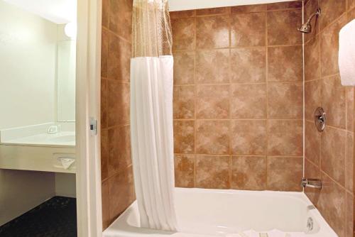 麦岭速8丹佛西酒店的带浴缸和盥洗盆的淋浴浴室