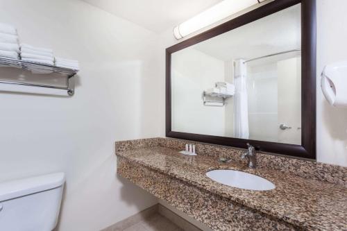 舍伍德帕克舍伍德帕克速8酒店的一间带水槽、镜子和卫生间的浴室