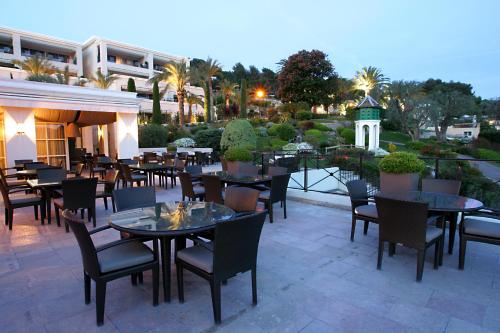 穆然皇家穆冉高尔夫豪华酒店及Spa的庭院内的餐厅,配有桌椅