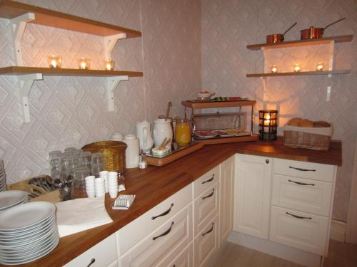 Lima索纳斯戈登住宿加早餐旅馆的厨房配有白色橱柜和带蜡烛的柜台。