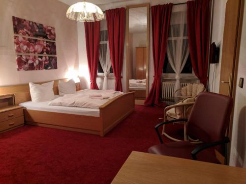 迪波尔迪斯瓦尔德迪波斯瓦尔德巴恩酒店的一间卧室配有红色地毯和红色窗帘的床
