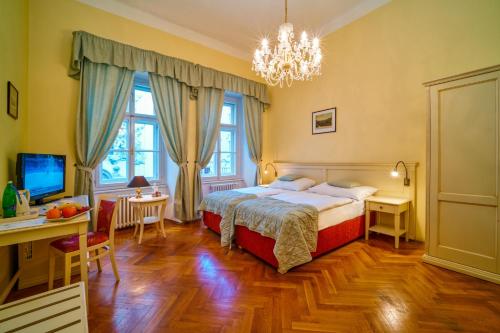 布拉格Josephine Old Town Square Hotel - Czech Leading Hotels的一间卧室配有一张床、一张桌子和一台电脑