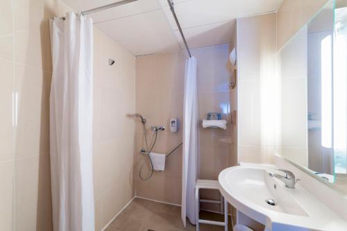 Saint-RémyB&B HOTEL Chalon-Sur-Saone Sud的带淋浴和盥洗盆的白色浴室