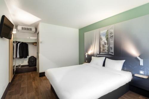 科尔贝埃索讷B&B HOTEL Corbeil-Essonnes的卧室配有一张白色大床和一个衣柜