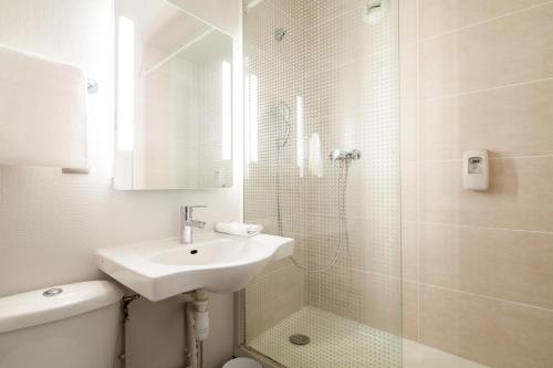 科尔贝埃索讷B&B HOTEL Corbeil-Essonnes的白色的浴室设有水槽和淋浴。