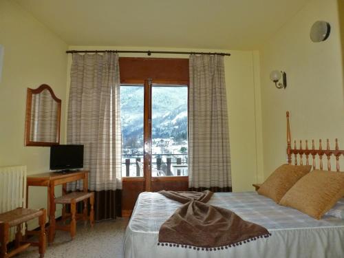 博索斯特加罗纳酒店的一间卧室配有一张床、一张书桌和一个窗户。