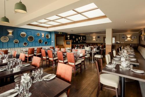 邓莱里Rochestown Lodge Hotel的餐厅内带桌椅的用餐室