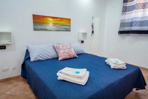 切法卢Casa Rubino的一间设有蓝色床和毛巾的房间