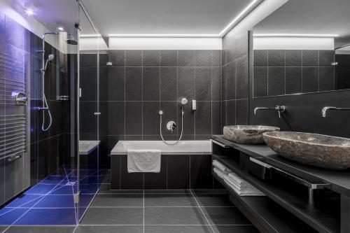 圣卡夏诺Hotel Conturines的带浴缸、水槽和淋浴的浴室