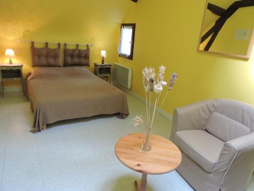 Mareuil-sur-CherLes Pres Verts的一间卧室配有一张床、一张沙发和一张桌子
