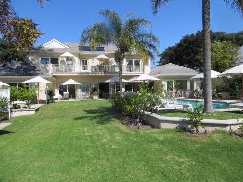 开普敦康斯坦提亚谷山林小屋的一座带游泳池和棕榈树的大房子