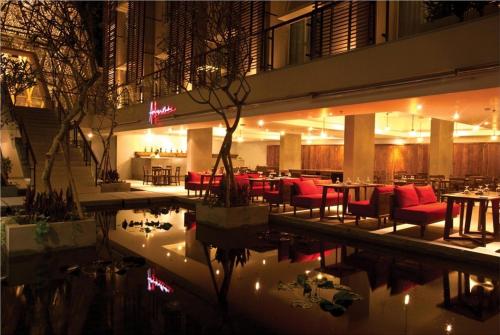 勒吉安阿南塔勒吉安酒店的一间设有桌子和红色椅子的餐厅,毗邻游泳池