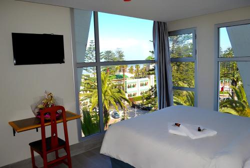 杰迪代Hotel Centre Ville的卧室设有白色的床和大窗户