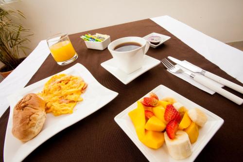 帕斯托Hotel Cafe y Miel的餐桌,包括两盘早餐食品和一杯咖啡