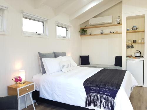 LeongathaAlkira的卧室设有一张白色大床和两个窗户。
