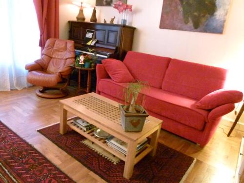 里昂St Pothin Village avec garage的客厅配有红色的沙发和桌子