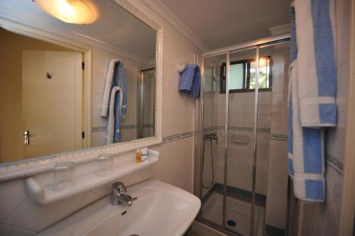英格兰海滩Taboga - Adults Only的浴室配有盥洗盆和带镜子的淋浴