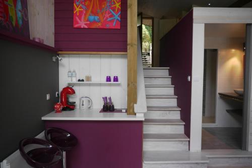 拉卡诺奥肯Un Matin D’été的厨房设有紫色墙壁和楼梯