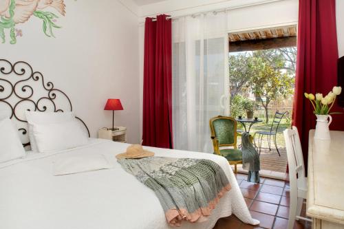 圣马迪拉莫特拉蒙塔纳酒店的一间卧室配有床和红色窗帘的窗户