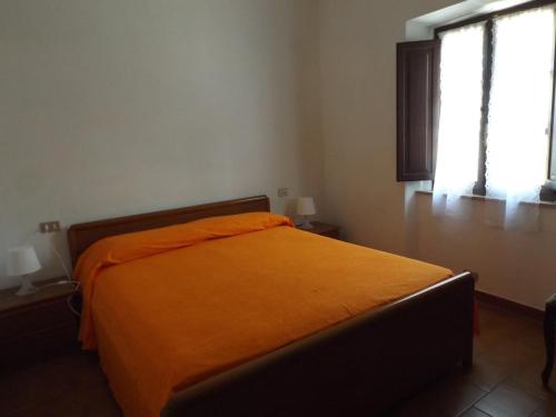 波蒙特Appartamento Il Girasole的带2扇窗户的客房内的橙色床