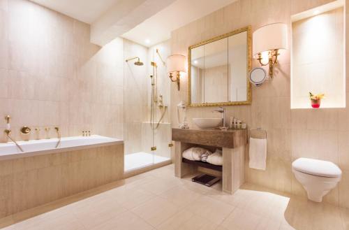 Cheserex博门特酒店的一间带水槽、浴缸和卫生间的浴室
