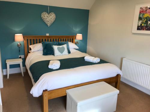 Broad ClystCrannaford Cottage的一间卧室设有一张带绿色墙壁的床