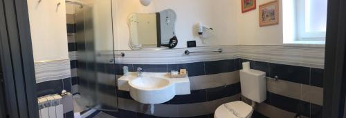 塞勒里古Hotel Marinella的一间带水槽、卫生间和镜子的浴室