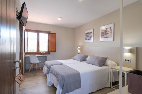 BoimortoCasa O Real的一间卧室配有一张床、一张书桌和一个窗户。