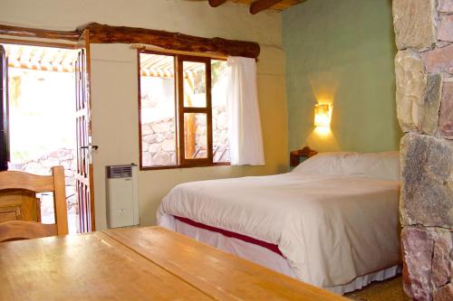 蒂尔卡拉Posada Don Juan的卧室配有床、桌子和窗户。