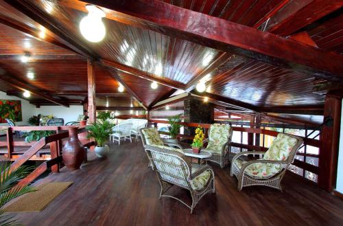 塞古罗港Hotel Adriattico的配有桌椅和木制天花板的房间