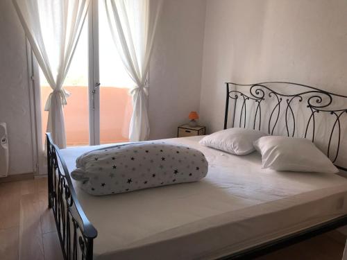 泰晤勒·苏尔·梅尔Residence port la galere的一张带白色床单和枕头的床以及窗户