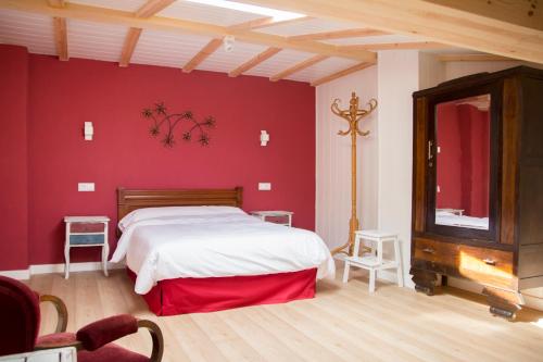 阿韦哈尔Casa Rural el Cedro的卧室配有白色的床和红色的墙壁