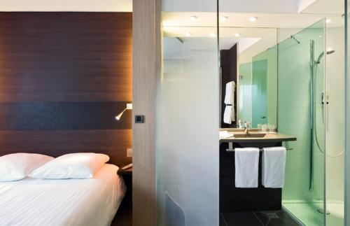 布雷斯特大洋洲布雷斯特酒店的一间卧室配有一张床,浴室设有淋浴。
