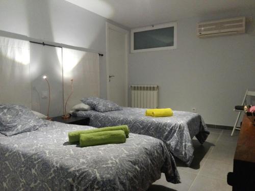 马德里COZY APARTAMENT 10 MINUTES FROM THE HEART OF MADRID的一间设有两张床铺的客房,配有绿色毛巾