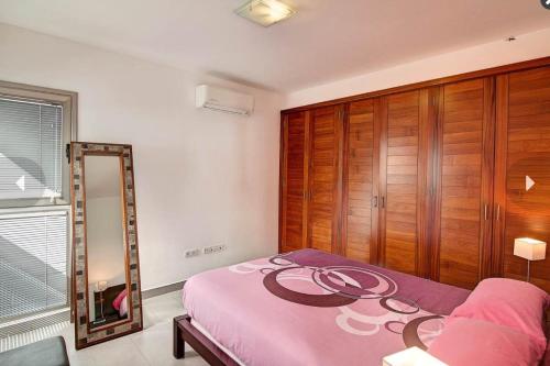 蒂哈拉费Villa Cristal的卧室配有粉红色的床和镜子
