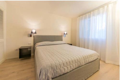 切尔沃港Appartamento Il Principe的一间卧室设有一张大床和一个窗户。