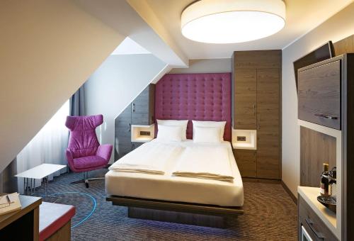 杜塞尔多夫慕尼黑斯塔迪特酒店的酒店客房带一张床和一个紫色床头板