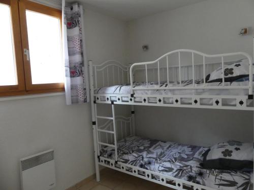 勒布罗伊斯Les Lys Orangés的一间卧室设有两张双层床和一扇窗户。
