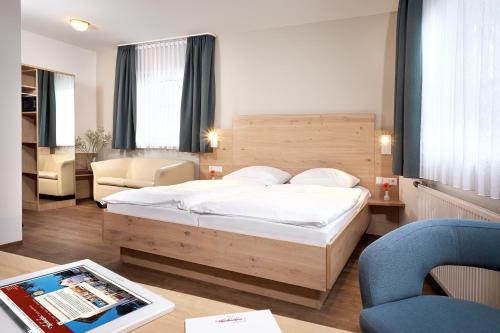 乌姆基希赫布登酒店的一间卧室配有一张床和一张桌子及一个平板电脑