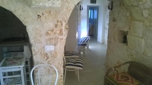 奥斯图尼Trullo saraceno的一间设有一组椅子的石墙客房