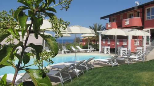 圣多米尼卡博尔戈迪圣巴巴拉酒店的一座带椅子和遮阳伞的游泳池位于一座建筑旁边