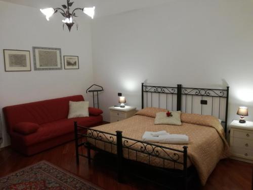 特伦托艾特波托尼住宿加早餐旅馆的一间卧室配有一张床和一张红色的沙发