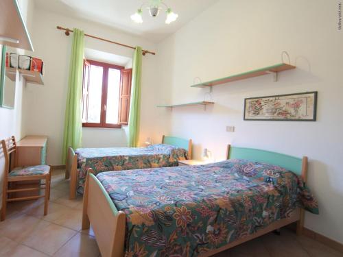 坎波内莱尔巴Villa La Pila的一间卧室设有两张床和窗户。