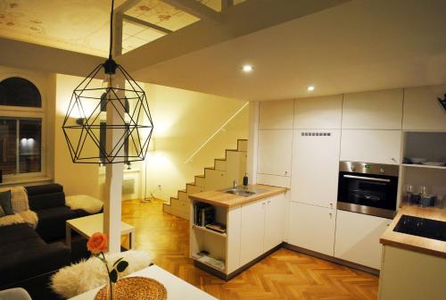 奥洛穆茨Apartments Centre in Style的一间带厨房和楼梯的客厅