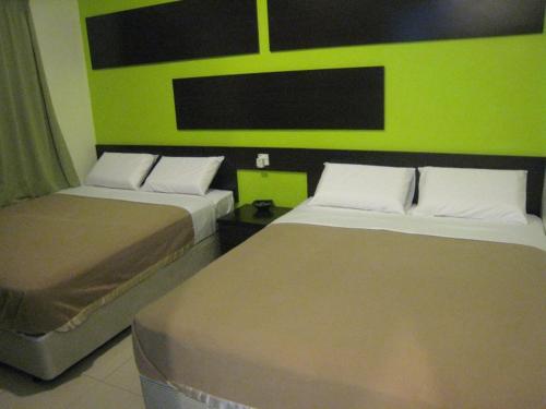 实兆远特罗皮卡那经济型酒店的绿墙客房的两张床