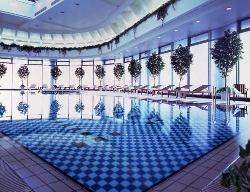 大阪大阪帝国酒店的一座大型游泳池,位于一座带窗户的建筑内