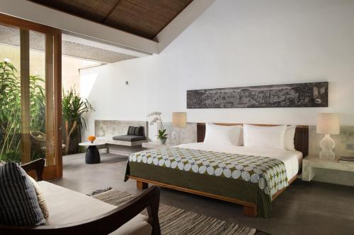 沙努尔Atelier TE Designer Guesthouse的一间卧室设有一张床和一间客厅。