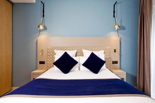 波尔多波尔多住家酒店的一间卧室配有蓝色和白色的床和两个蓝色枕头