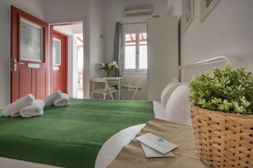 米克诺斯城阿罗度公寓的一间设有绿床和毛巾的客房