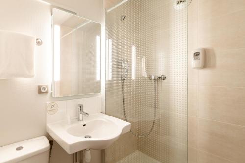 La Queue-en-BrieB&B HOTEL La Queue En Brie的白色的浴室设有水槽和淋浴。